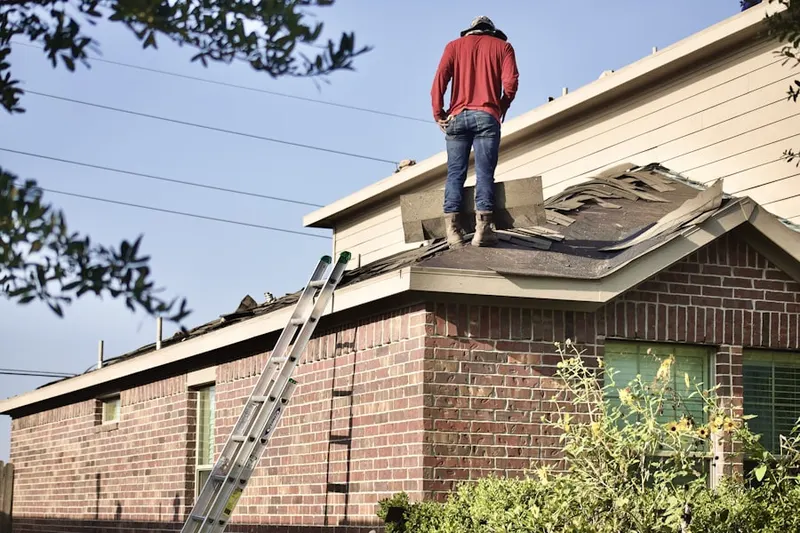 Professional roofer working on a residential roof in Milano